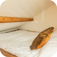 Wooden bed with white linen covers