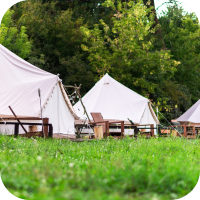 Three glamping tents with lawn chairs