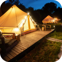 Side perspective of Glamping tent with lights at nightfall