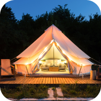 Frontal view of glamping tent with lights and bed at nightfall